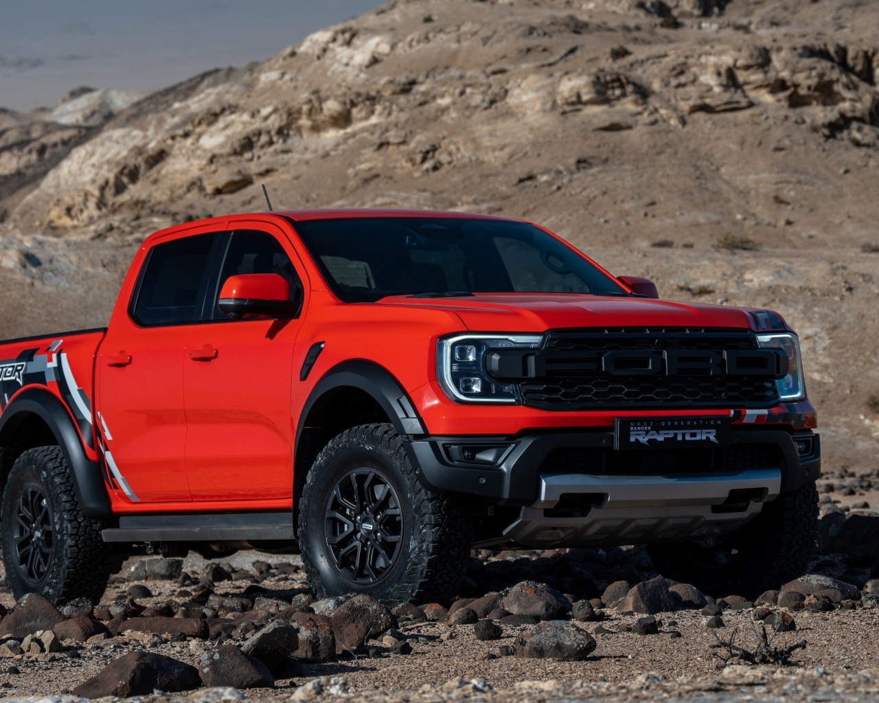 Красный пикап Ford Ranger Raptor 2023 года в горах