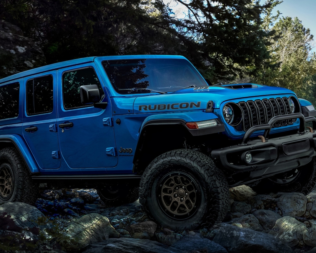 Синий Jeep Wrangler Unlimited Rubicon 2023 года на бездорожье