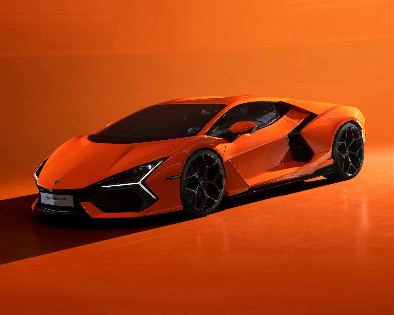 Автомобиль Lamborghini Revuelto 2023 года на оранжевом фоне