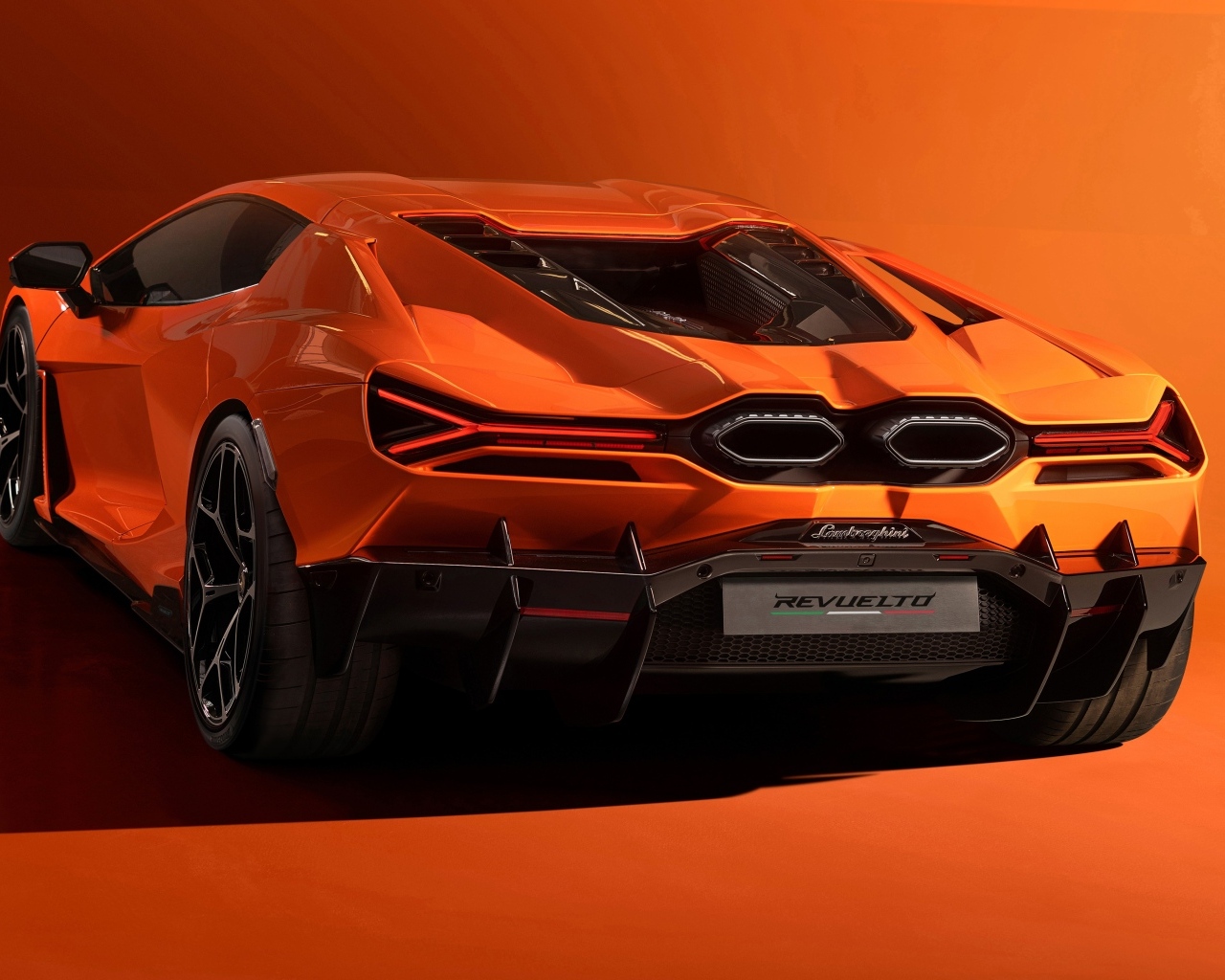 Оранжевый автомобиль Lamborghini Revuelto 2023 года вид сзади