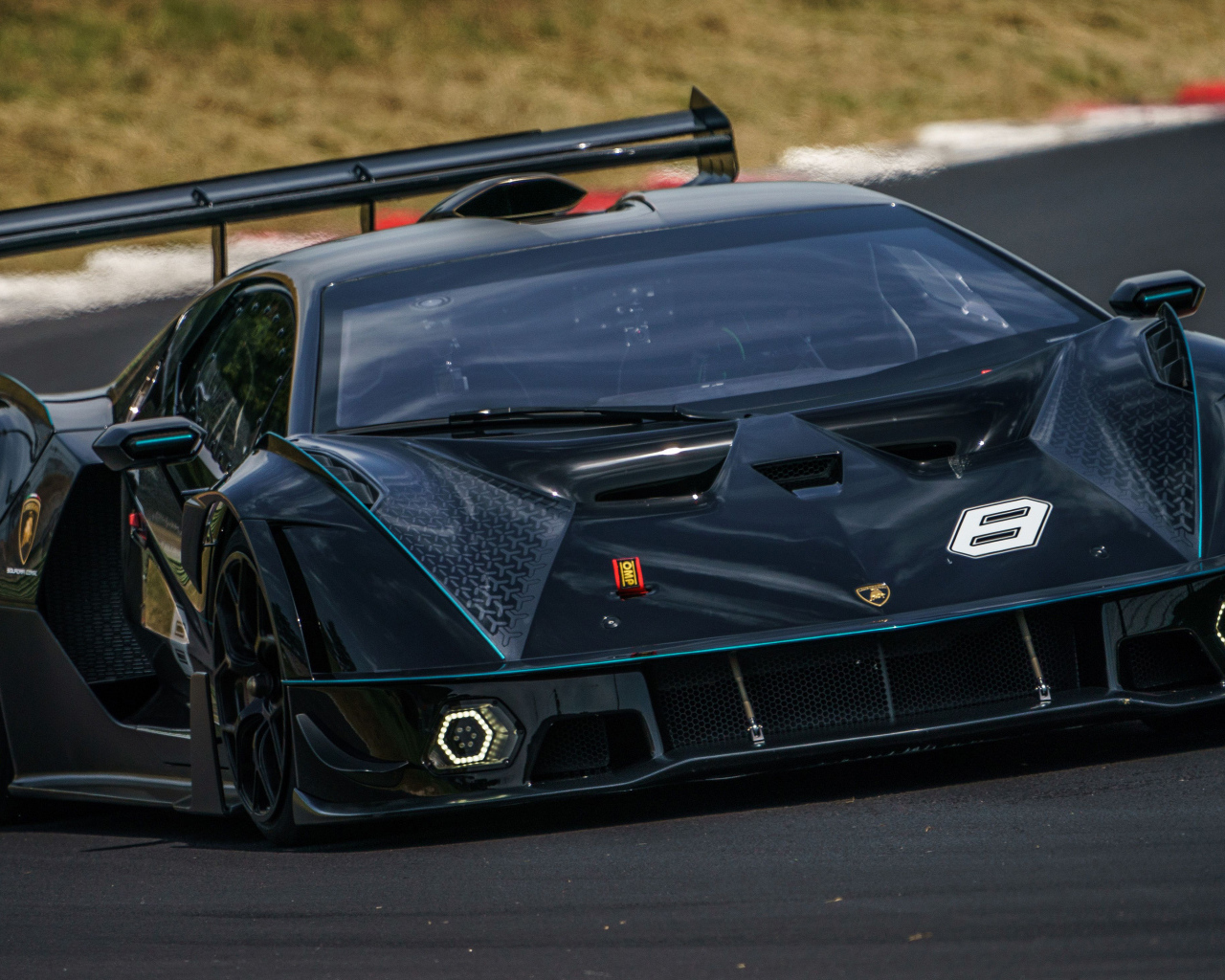 Черный спортивный Lamborghini Essenza SCV12 на гоночной трассе 