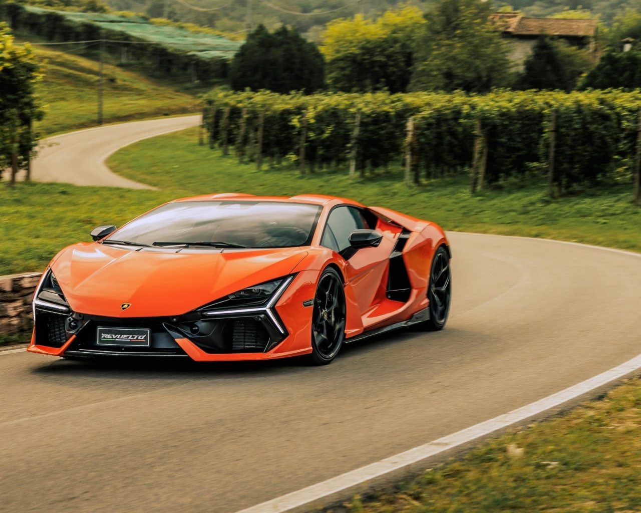 Оранжевый автомобиль Lamborghini Revuelto на дороге