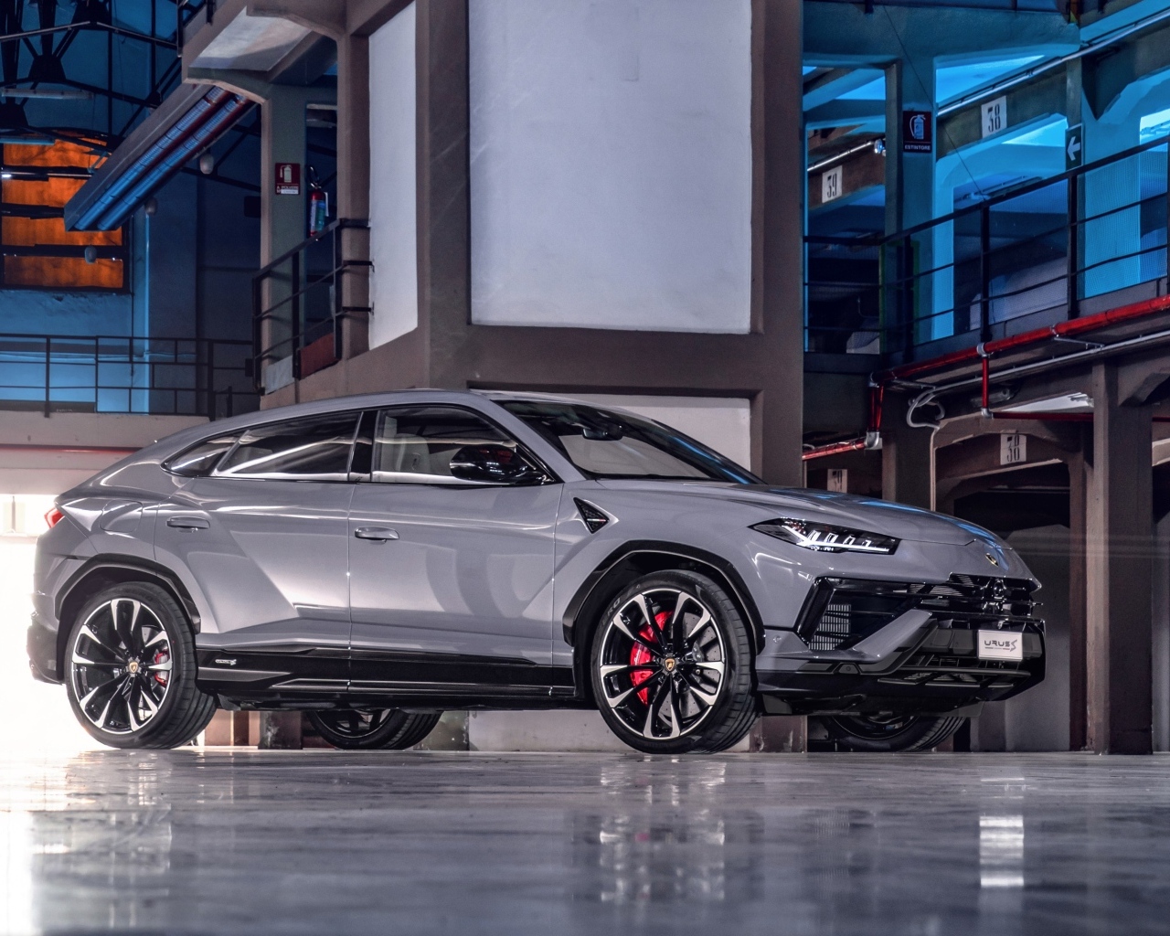 Серебристый автомобиль Lamborghini Urus S в здании