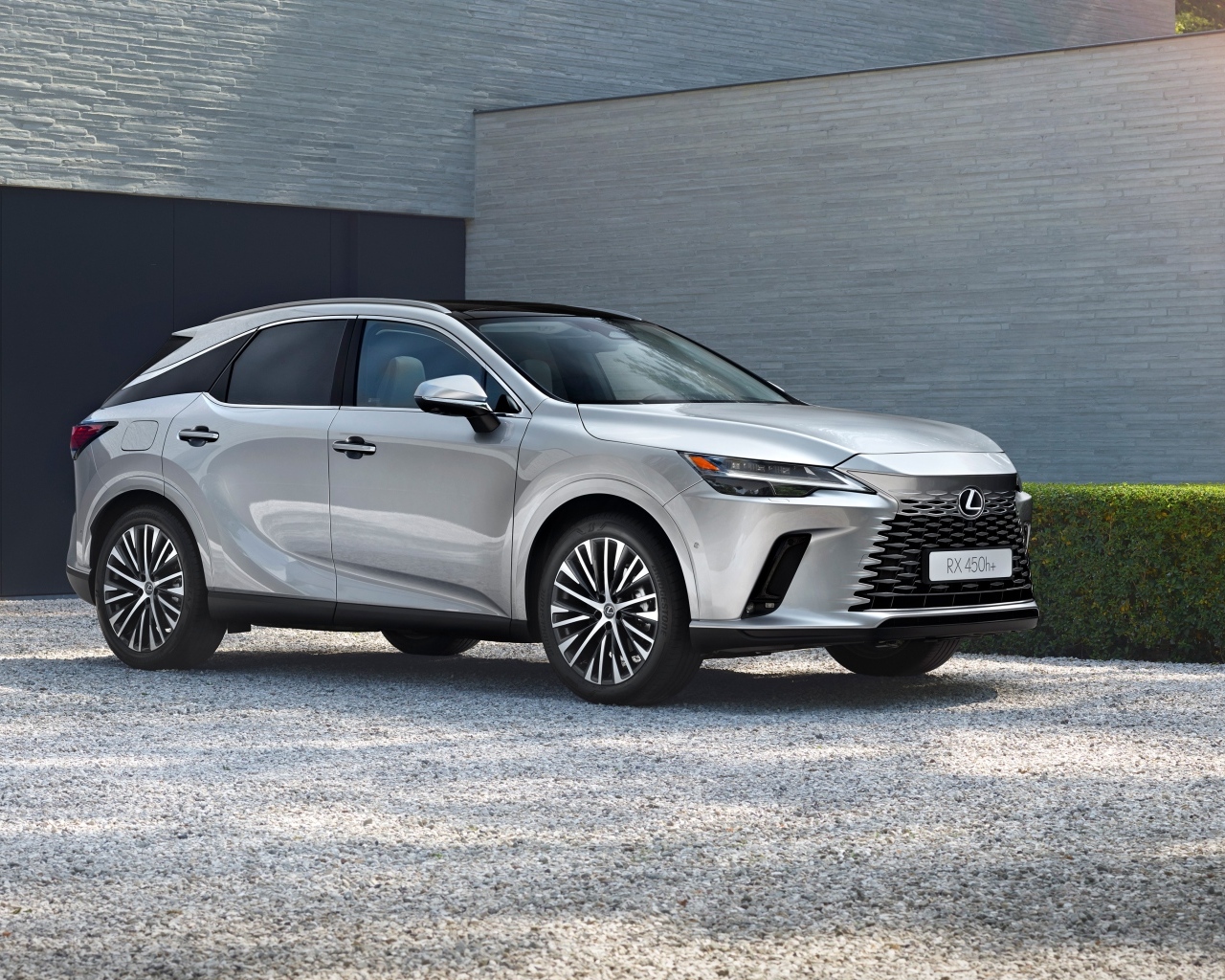 Серебристый внедорожник Lexus RX 450h+ у здания
