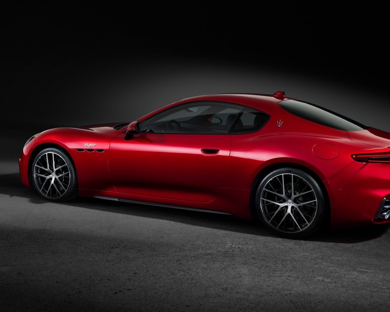 Красный автомобиль Maserati GranTurismo Trofeo 2023 на сером фоне