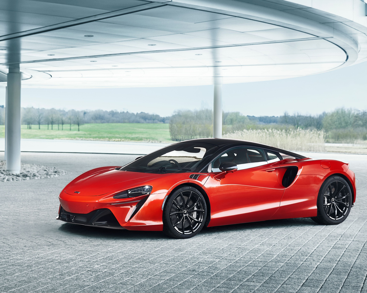 Спортивный красный автомобиль McLaren Artura 2023 года