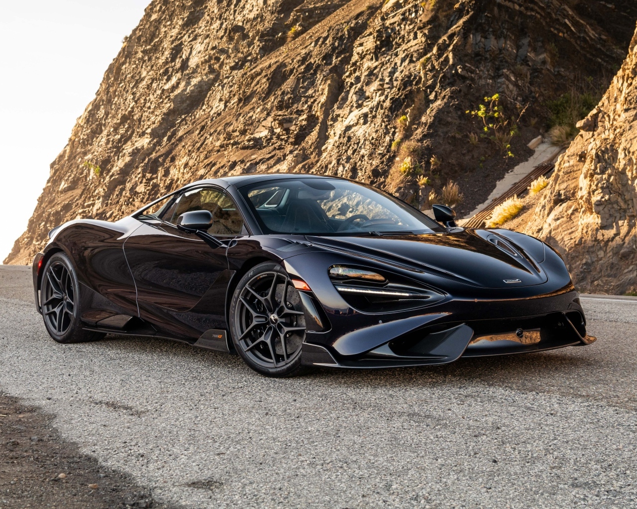 Черный спортивный автомобиль McLaren 765LT Spider у гор