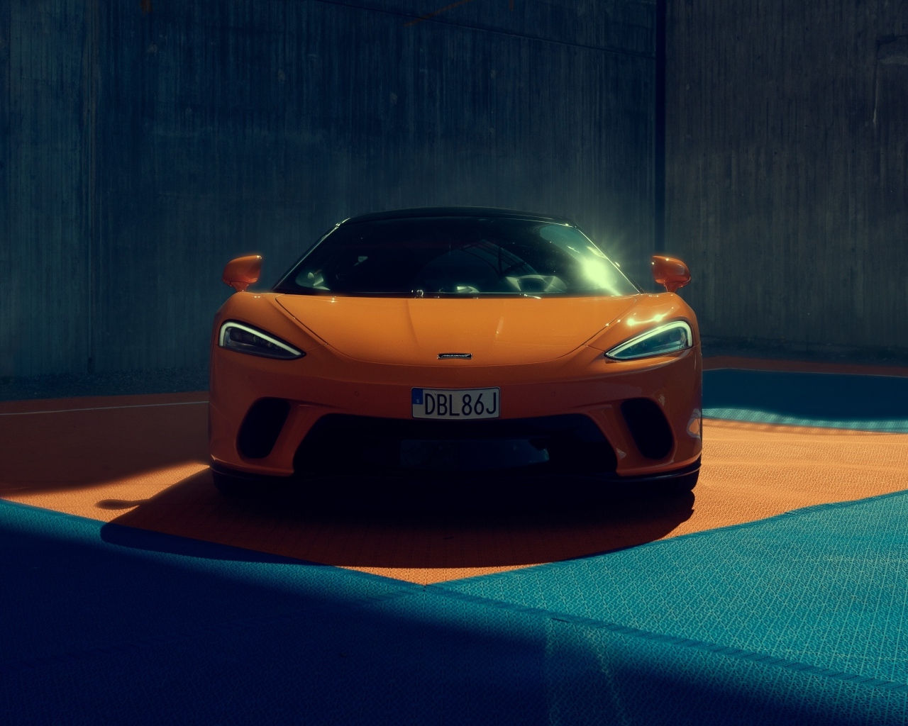 Оранжевый автомобиль McLaren GT вид спереди