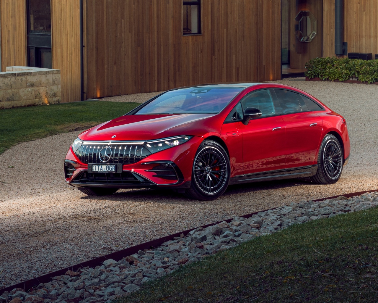 Красный автомобиль Mercedes-AMG EQS 53 4MATIC+  у дома