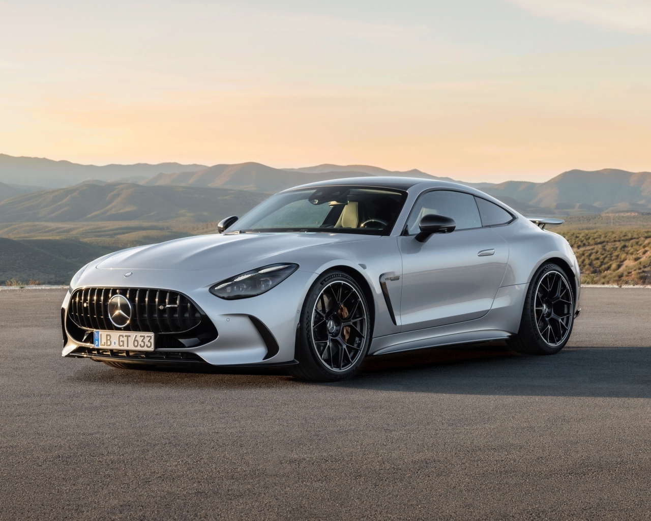 Серебристый автомобиль Mercedes-AMG GT 63 4MATIC+ 2023 года на фоне гор