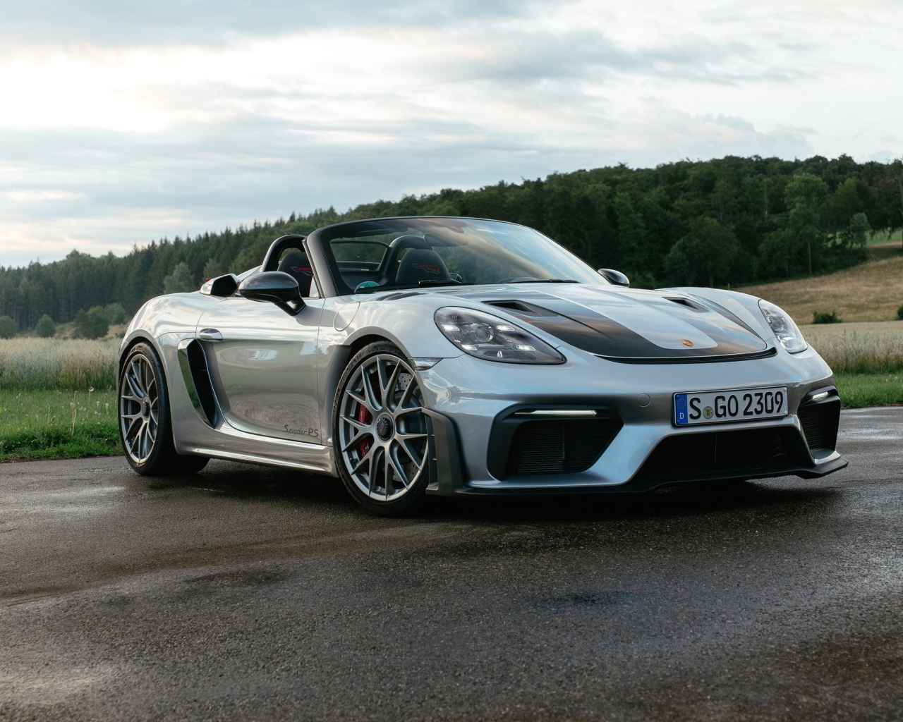 Быстрый Porsche 718 Spyder RS на мокрой дороге