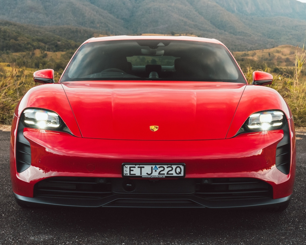 Красный автомобиль Porsche Taycan GTS вид спереди