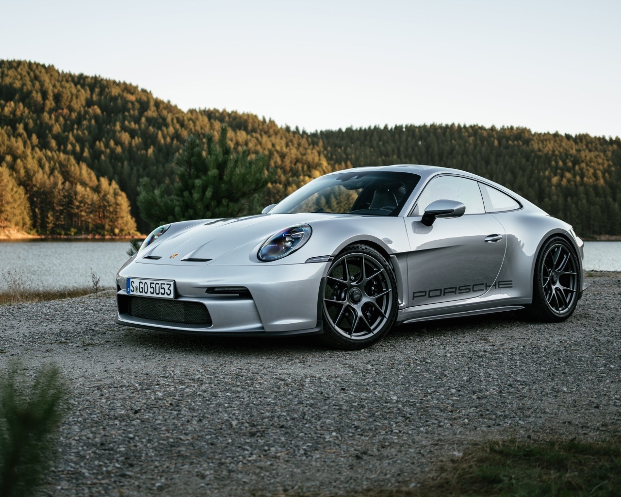 Серебристый автомобиль Porsche 911 ST 2023 года у воды