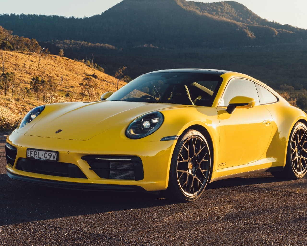 Желтый быстрый автомобиль Porsche 911 Carrera GTS вид спереди