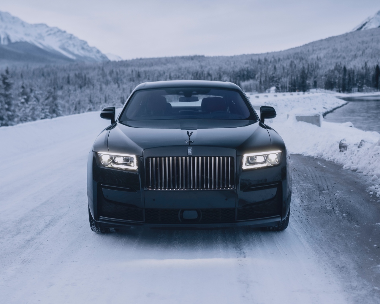 Черный автомобиль Rolls-Royce Black Badge Ghost  на зимней дороге