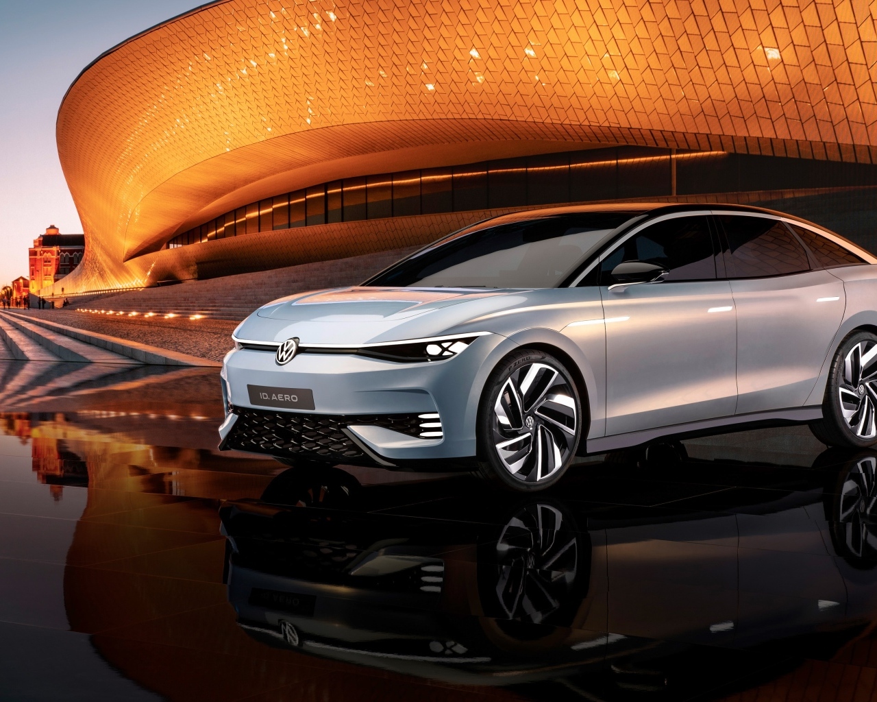 Серебристый автомобиль Volkswagen ID. AERO у здания