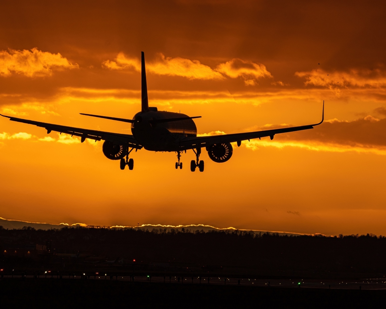 Самолет идет на посадку на закате 