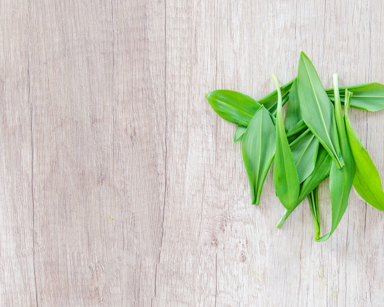 Пучок зеленых листьев на деревянной поверхности 