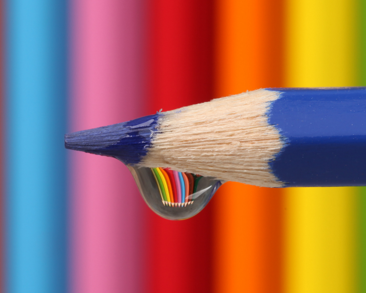 Капля воды стекает с синего карандаша