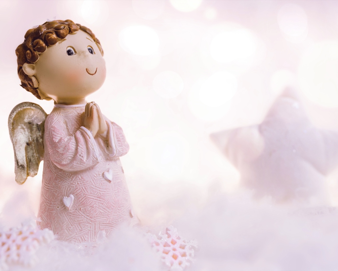 Маленькая статуэтка ангела стоит на снегу