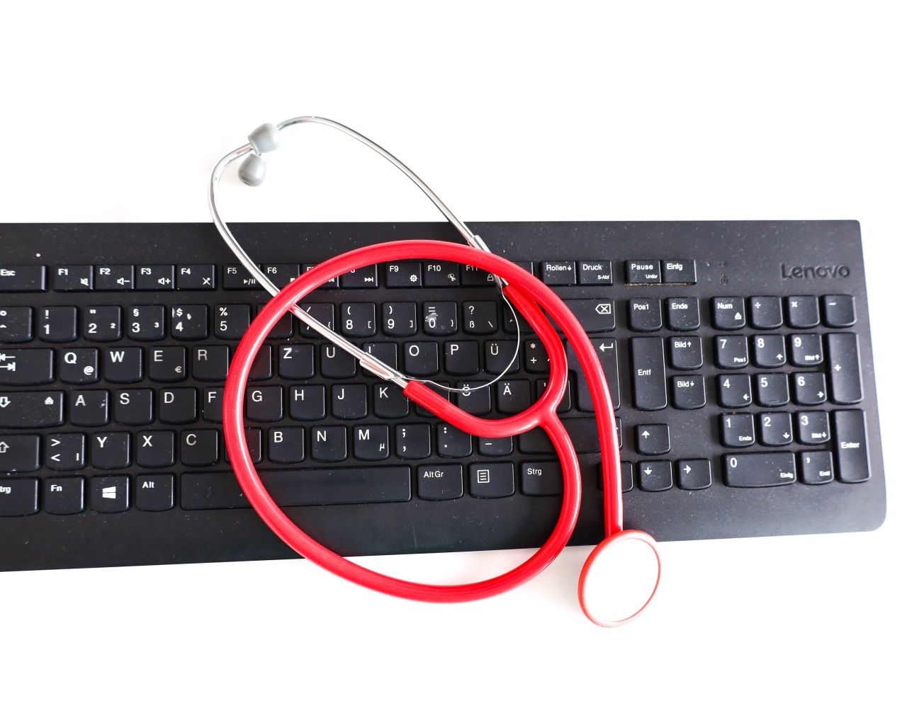 Черная клавиатура с фонендоскопом на белом фоне