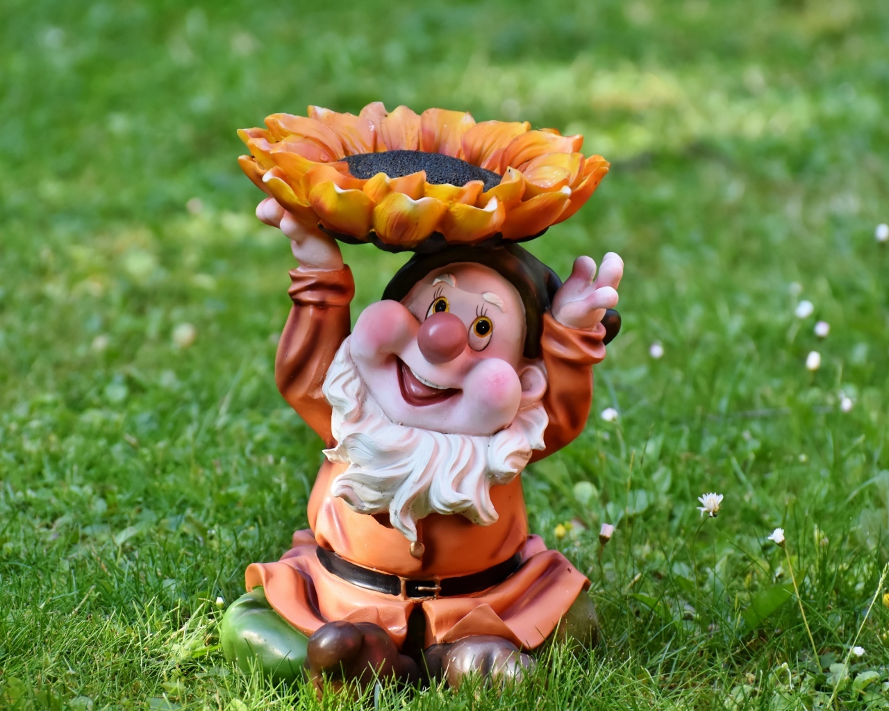 Садовая фигура гном за зеленой траве