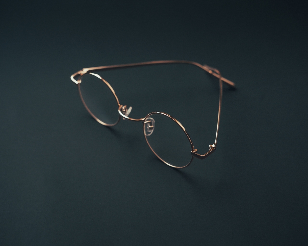 Очки лежат на серой поверхности