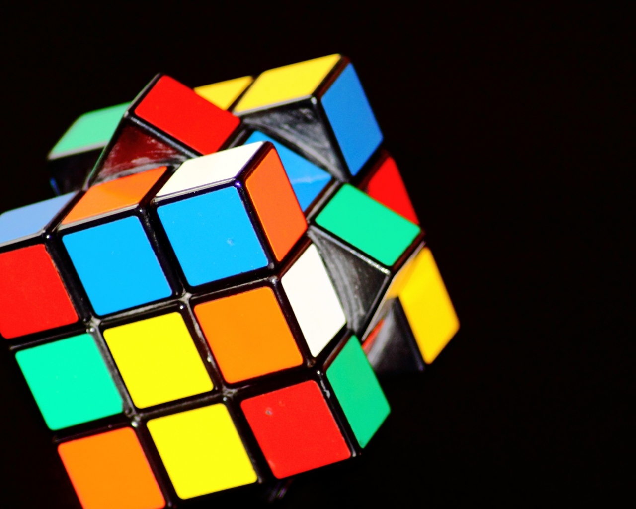 Разноцветный кубик Рубика на черном фоне