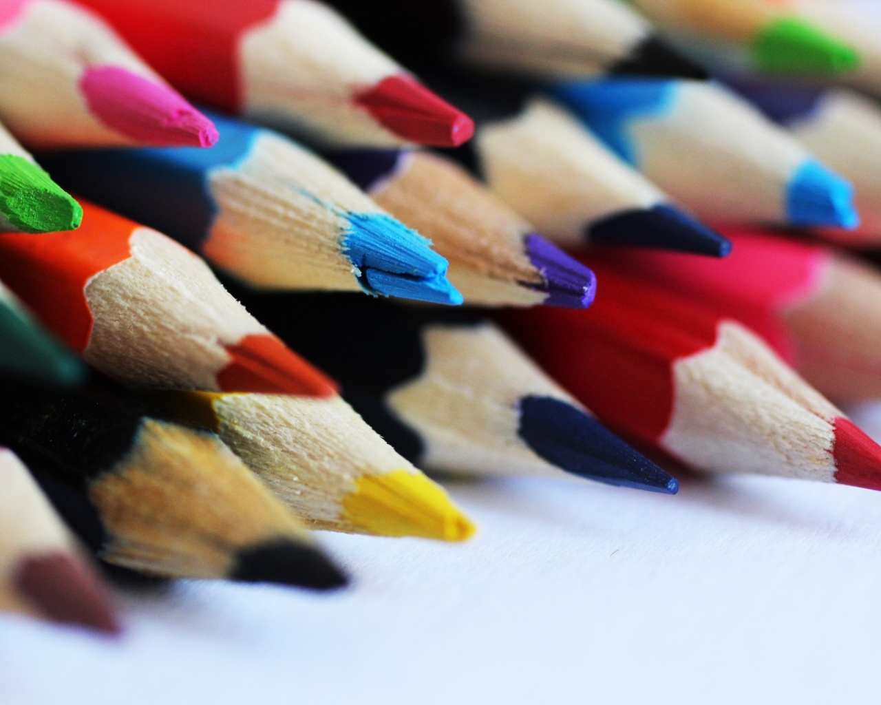 Разноцветные заточенные карандаши на столе