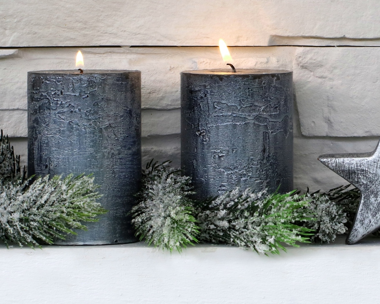 Две большие зажженные свечи у стены