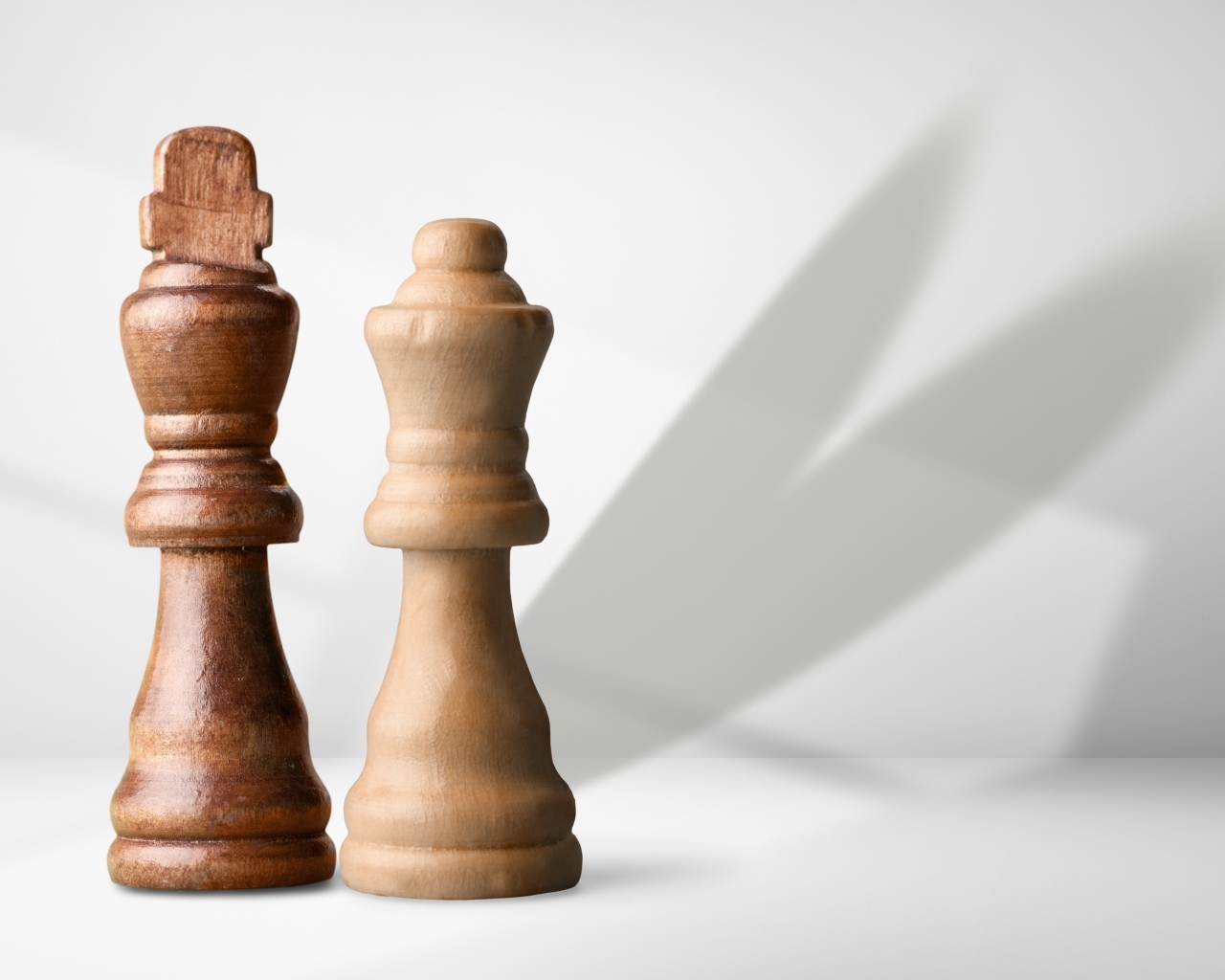 Две деревянные шахматные фигуры на сером фоне