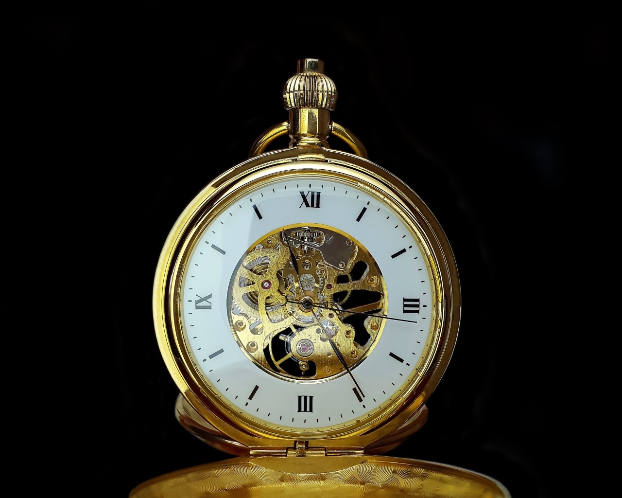 Старинные золотые карманные часы на черном фоне