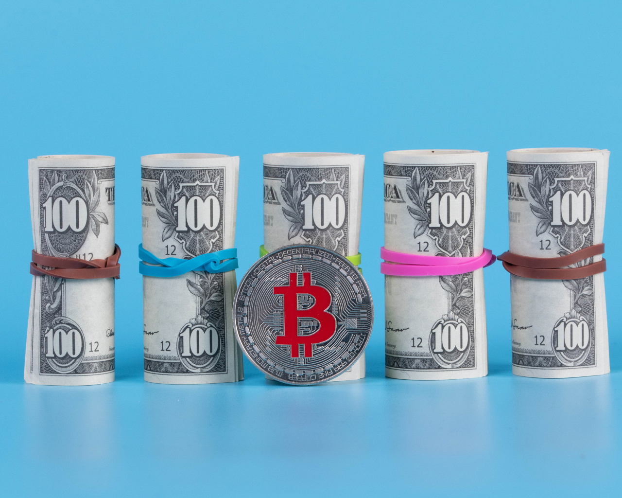 Доллары с монетой биткоин на голубом фоне