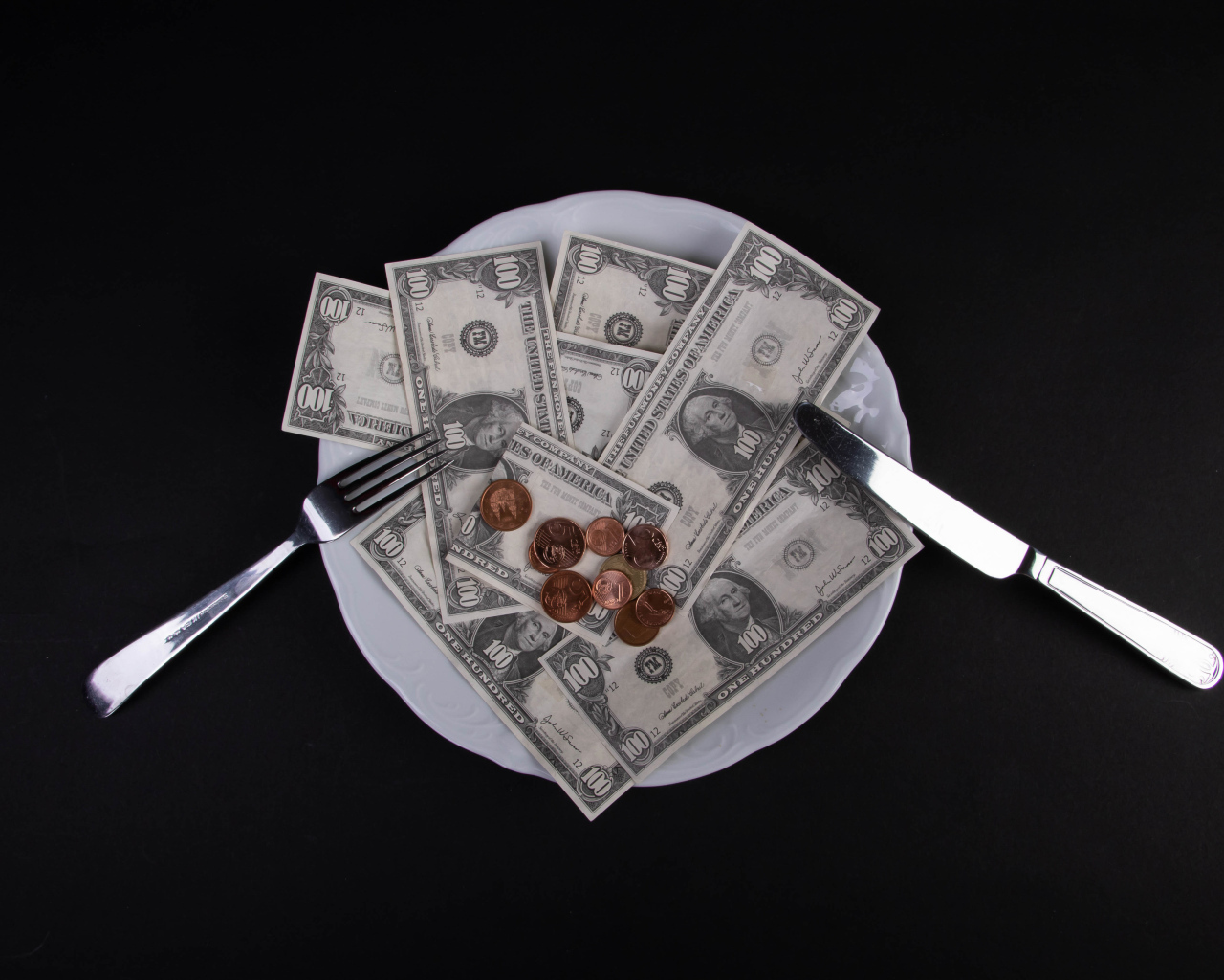 Тарелка с долларами на черном фоне