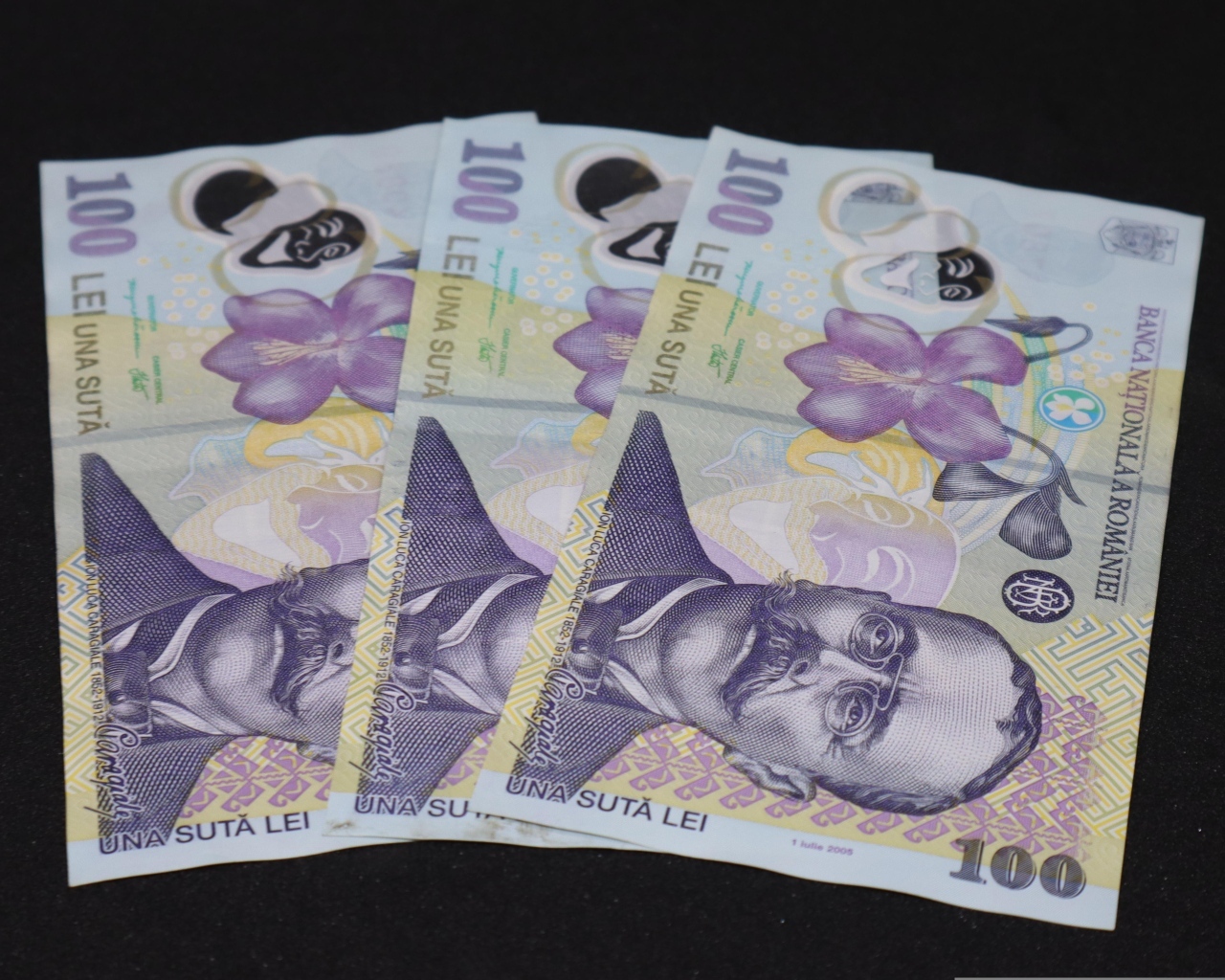 Три купюры на черном фоне