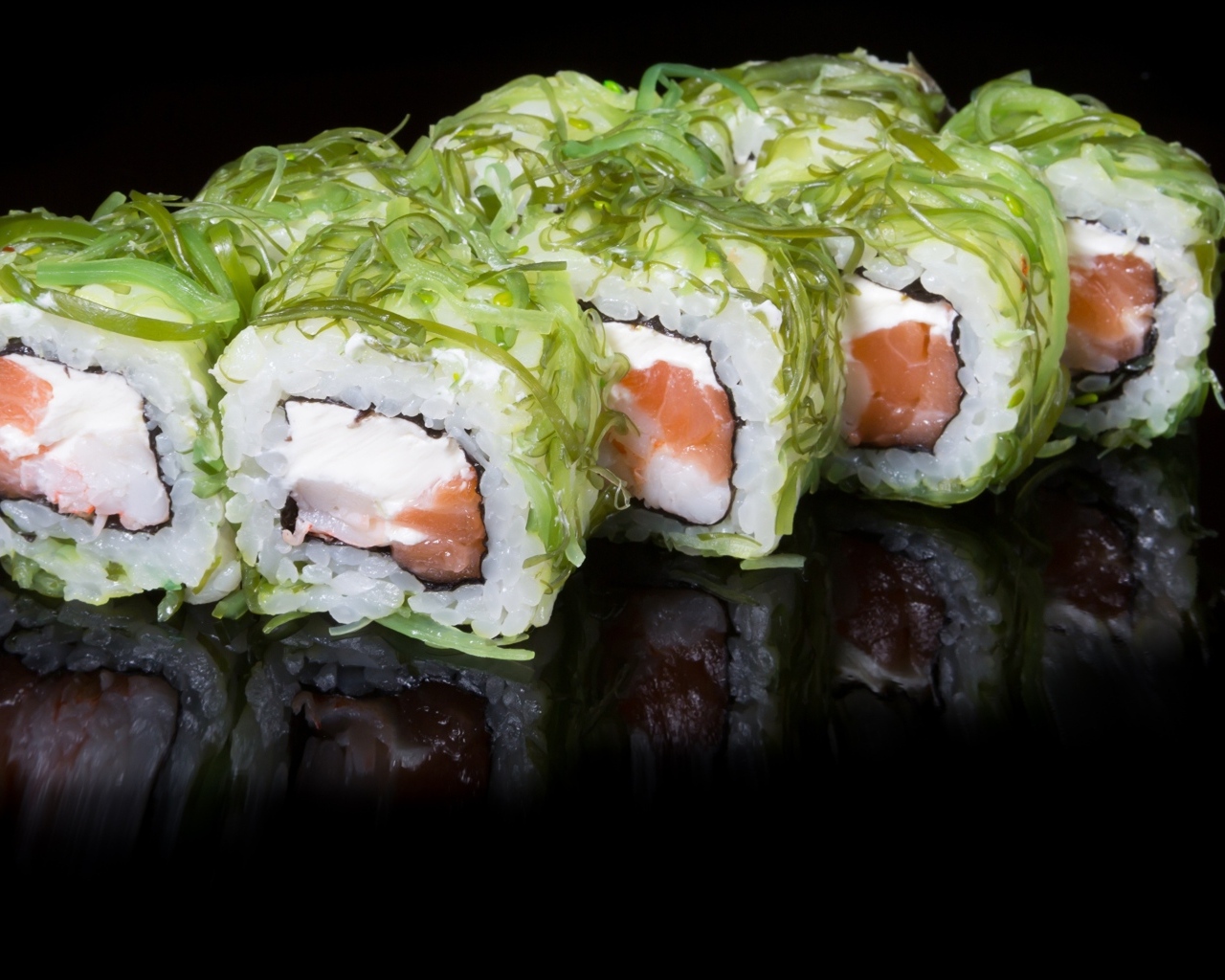 Аппетитные роллы с рыбой на черном фоне