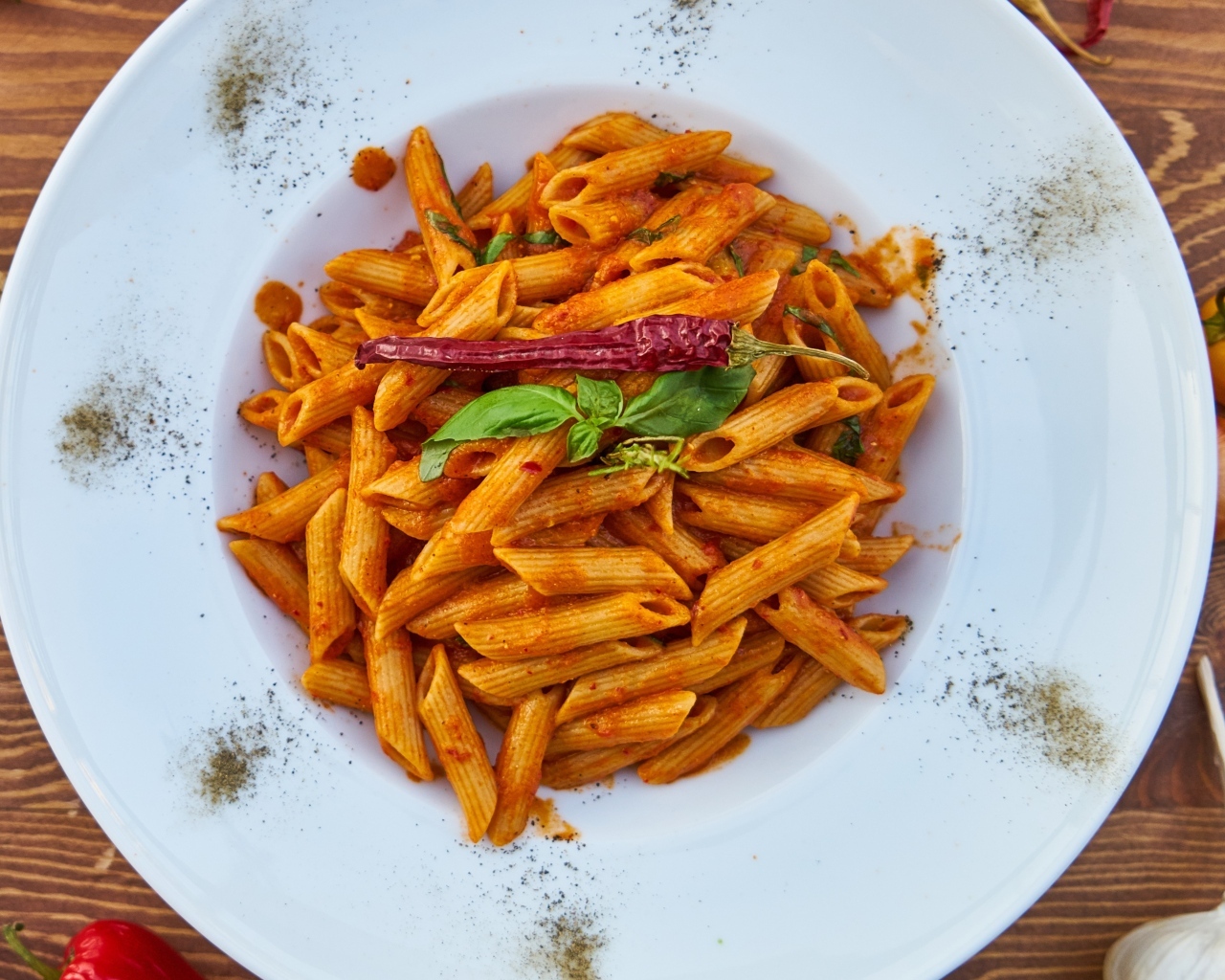 Вареные макароны на большой тарелке с красным перцем