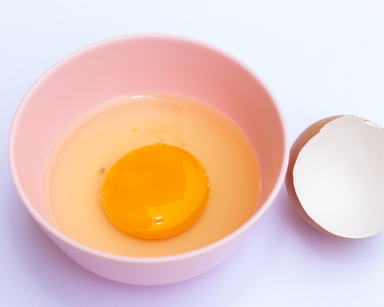 Разбитое яйцо на столе со скорлупой