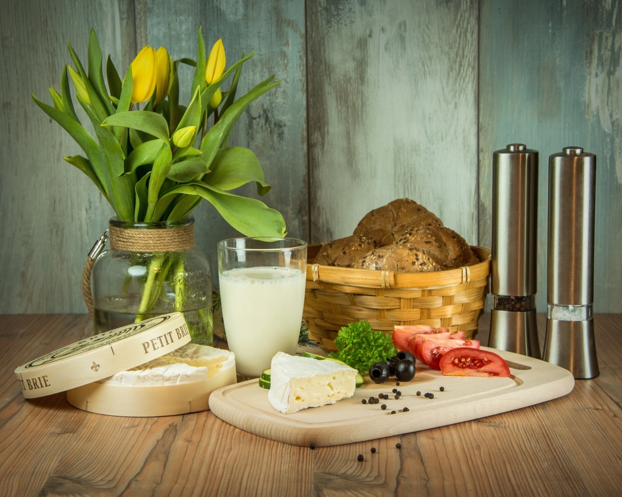 Сыр с овощами на столе с хлебом и букетом тюльпанов