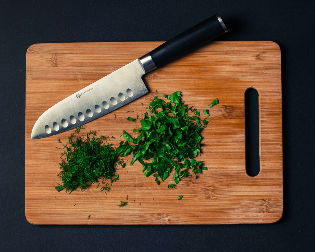 Нарезанная зелень на доске с ножом