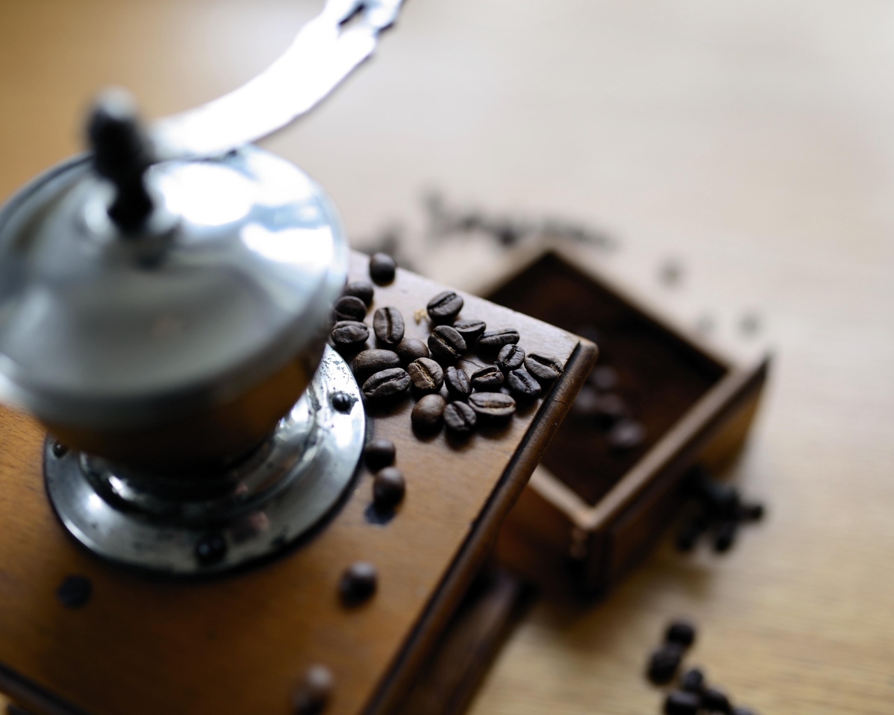 Кофемолка на столе с зернами