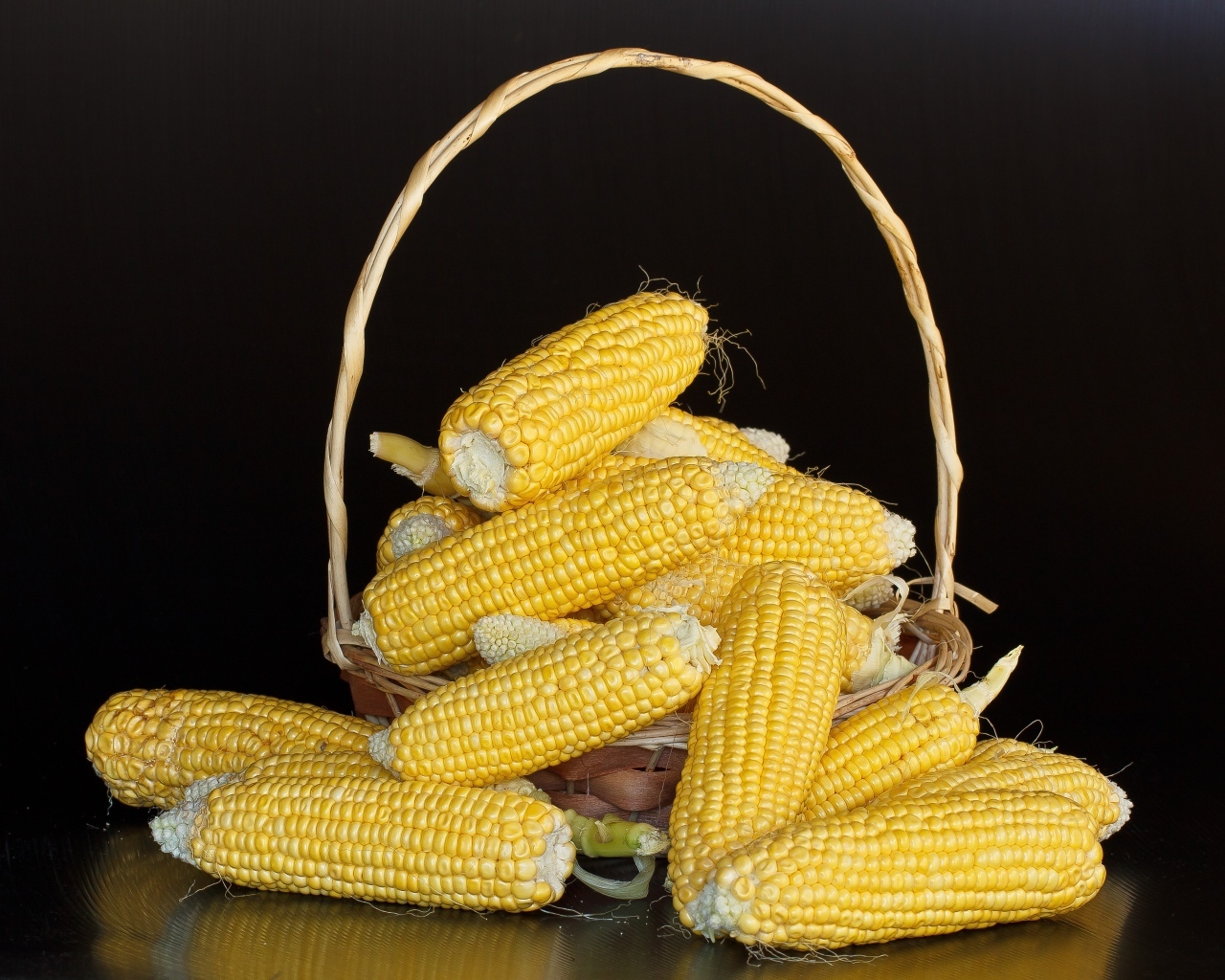 Кукуруза в корзине на черном фоне