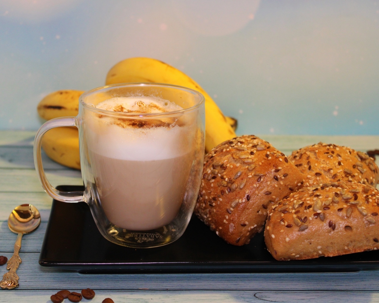 Чашка какао на столе с булочками и бананами