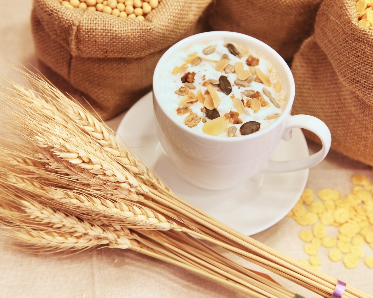 Чашка молока с хлопьями на столе с пшеницей