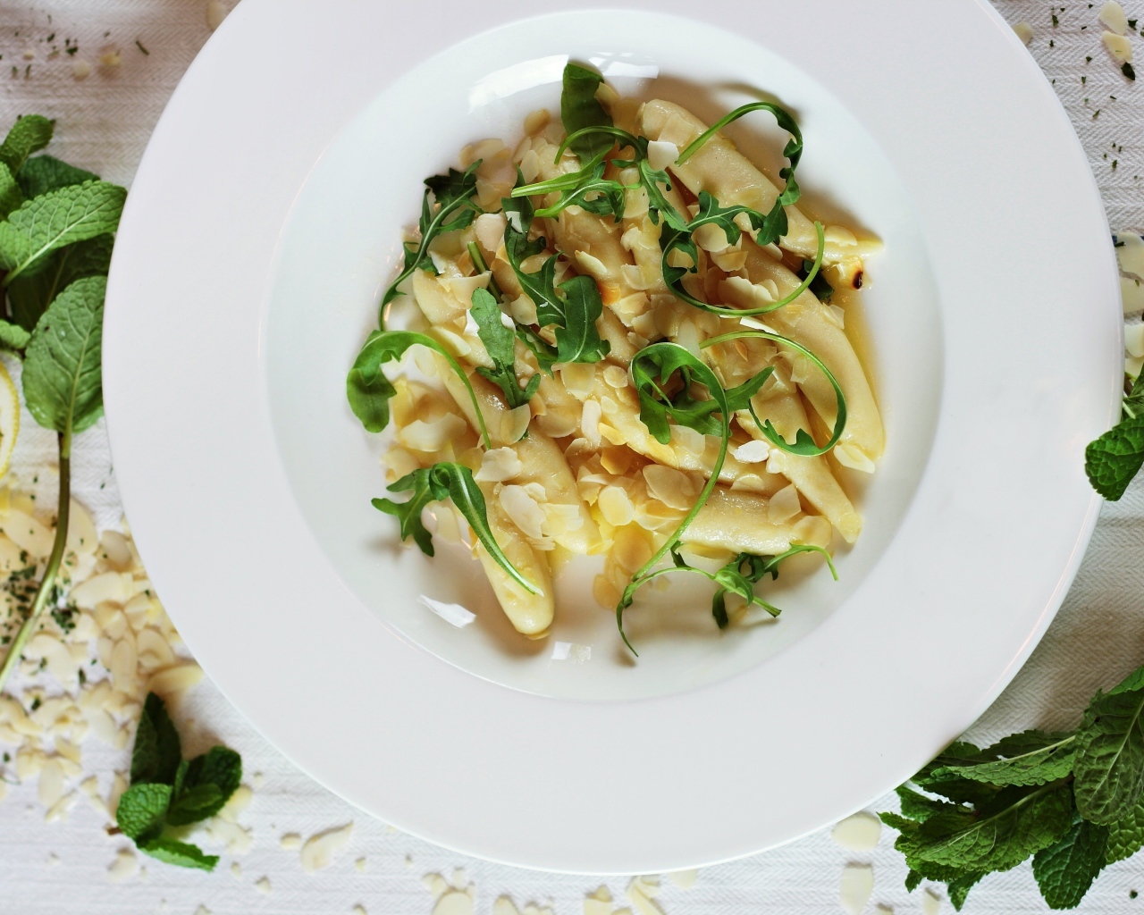 Блюдо с листьями рукколы в большой белой тарелке