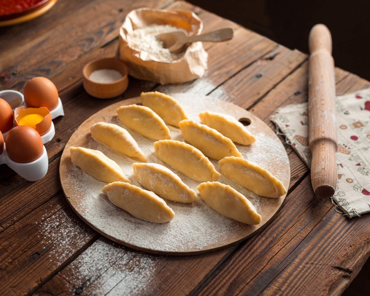 Вареники на столе  с яйцами и мукой