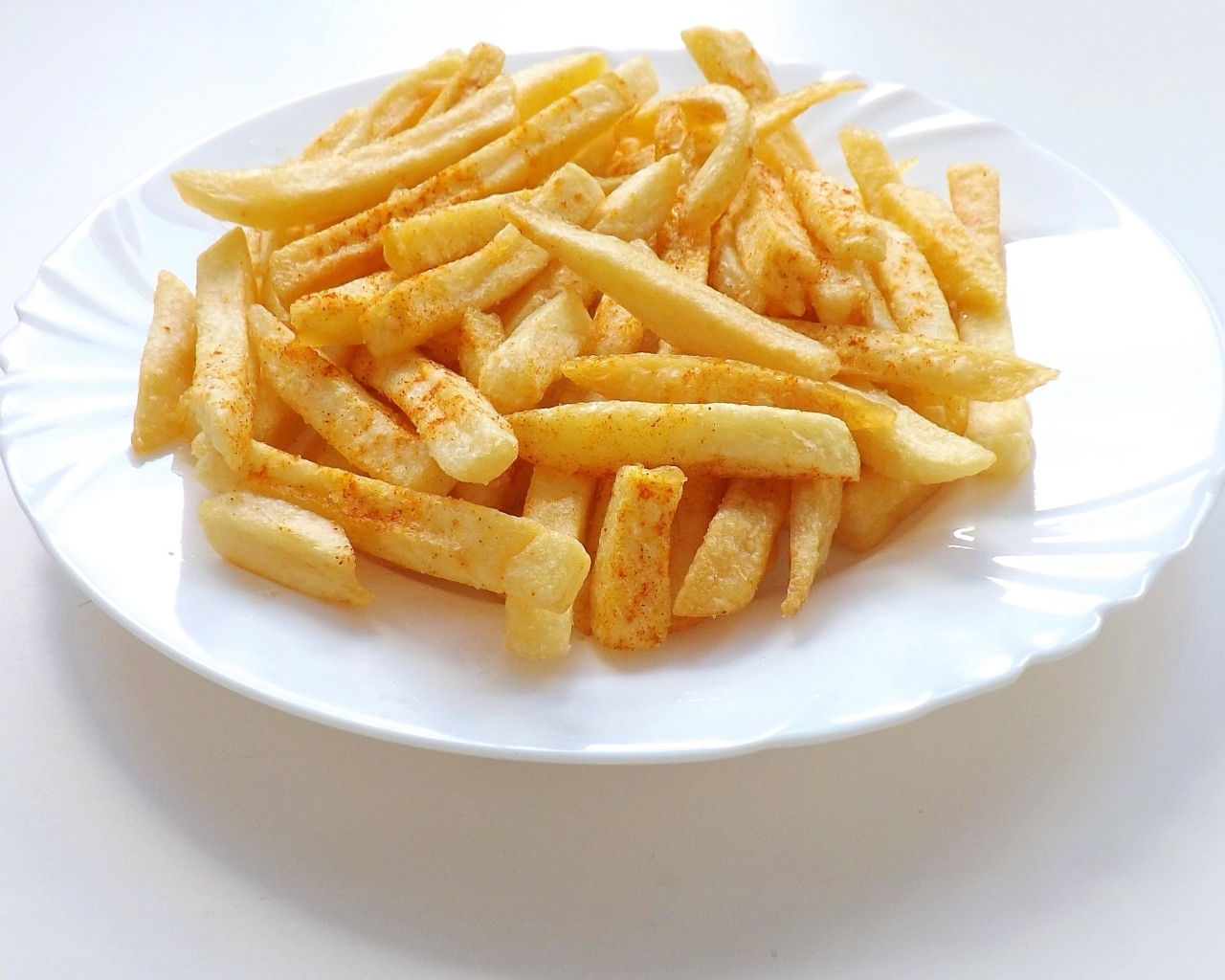 Картофель фри на большой белой тарелке