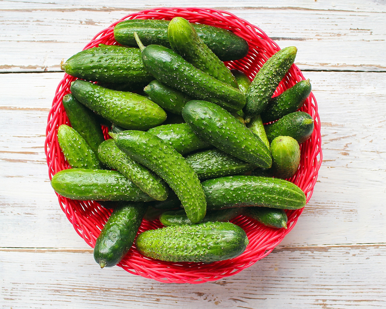 Свежие зеленые огурцы в корзинке на столе