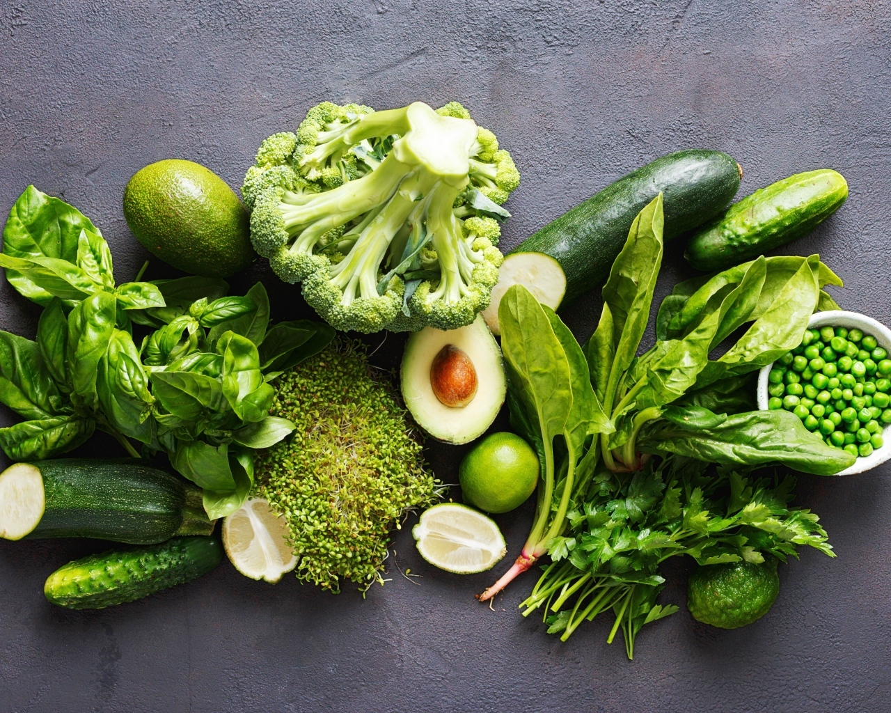 Свежие зеленые овощи на сером столе