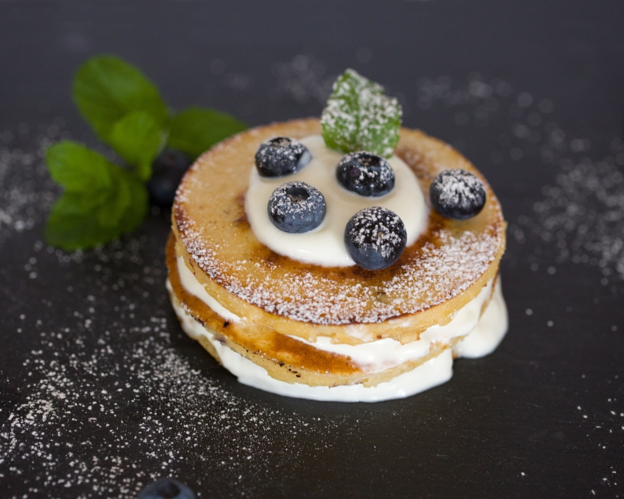 Оладьи с кремом и ягодами черники на столе